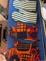 Four oven mitts lined up: two striped, two abstract