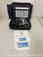 Open carrying case showing drone, controller, accessories, and instruction sheet