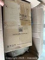 Overall view of shipping box with sealed SPIRA carton and plastic-wrapped item