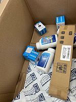 Overview showing LED bulb boxes and chemical bottles inside larger carton