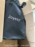 Black Joyesy tote bag visible inside box