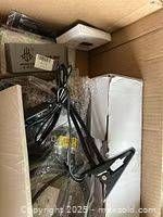 Overview of box contents showing clamp device, cords, silver box and white module