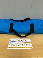 Blue carry bag with black handles on table
