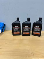 Three sealed Yamalube Trans Oil Plus bottles on table