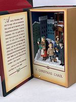 Open book showing interior Dickens scene and text panel