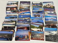 numerous stacks of U.S. chrome postcards spread on table