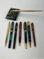 Group shot of marble pen holder, desk pen and seven branded pens/pencils