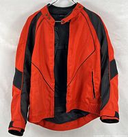 Front view of red and black Motoboss motorcycle jacket hanging