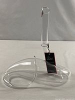 Full view of clear Riedel Snake decanter showing looped base and tall neck with hang tag