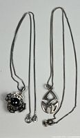 Both sterling silver necklaces laid flat with pendants visible