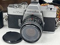 Front view of Minolta SR-T 201 with 50 mm lens and body cap