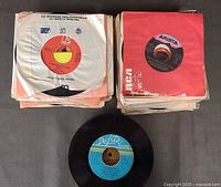 Stacks of sleeved 45 rpm records with one record displayed, label De-Lite Records