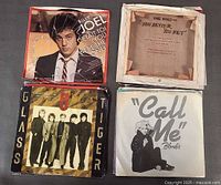 Four 45 rpm singles: Billy Joel, The Who, Glass Tiger, Blondie