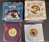 Stack of records including Grease picture sleeve and company sleeves