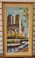 Front view of framed oil painting depicting Notre Dame Cathedral