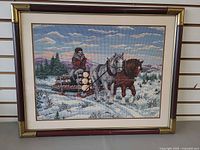 Front view of framed needlepoint showing winter scene