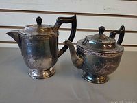 Front view of both Viners silver-plated pots