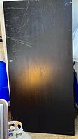 Top surface of black-brown tabletop showing scratches