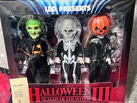 Front of sealed box showing three dolls in window