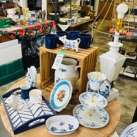 Overall view of lot showing lamp, tier stand, tray, jug, cow creamer, mugs and other blue and white decor items