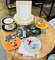Overall view of plates, cake stand, frame, tiered server and platter on round table