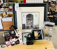 Group shot showing framed cafe print, suitcase, mug, diffuser, glass purse, napkins
