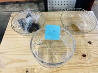 Three bowls and bag of metal place card holders displayed on table