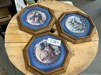 Front view of three framed plates on table