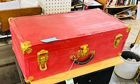 Closed trunk showing red exterior and brass hardware