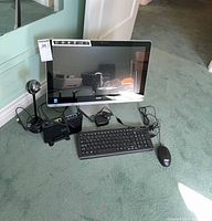 Front view of Acer all-in-one PC with keyboard, mouse, router, and webcam