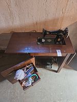 Top view of Singer machine, cabinet, open accessory compartment, cast-iron base