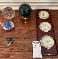 All items laid out: Movado plaque, marble sphere on stand, clear bubble paperweight, blue-green glass turtle, glass flower