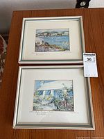 Both framed prints on table showing size and matching frames