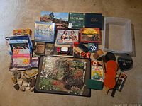 Overall lot layout showing board games, puzzles, sports items, bin