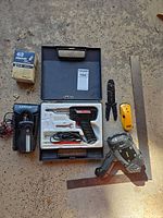 Overview of lot showing soldering gun kit, clamp meter, cordless drill, stud finder, connectors box, ruler and other items