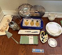 Group shot of all dinnerware, trays and utensils on floor