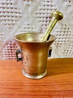 Mortar and pestle front view showing overall form and patina