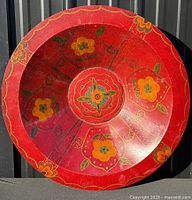 Full view of red hand-painted wooden bowl showing floral design