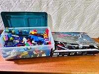 Overall view of plastic bin filled with LEGO bricks next to boxed partial set