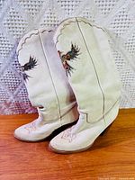 Side view of both boots showing eagle motif and overall condition