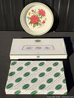 Loose platter with floral motif displayed, two boxed platters beneath