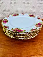 Stack of eight Old Country Roses plates showing pattern and gold rim