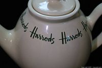 Side view showing Harrods script and lid
