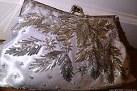 Front view of beaded white clutch showing clasp and beadwork