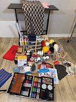 Overall lot layout showing art case, yarn, beads, fabric, wood items, storage tower