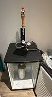 Front view of kegerator with tap tower, regulator, drip tray and CO₂ tank visible