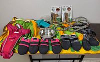 All items laid out: dog boots sets, harness, bowls, chews, snuffle mat, mold, rope lead