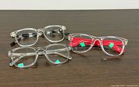 Front view of three clear eyeglass frames on table