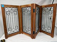 Gate fully extended showing four panels with wood frames and iron scrollwork