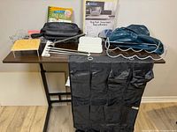 All items displayed on table including shoe organizer, rug pad, yoga ball, wine rack, cord trays, towel rack, shelf, flower press